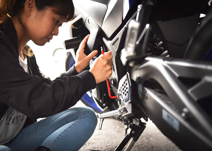 バイクのメンテナンスをするスタッフのアン